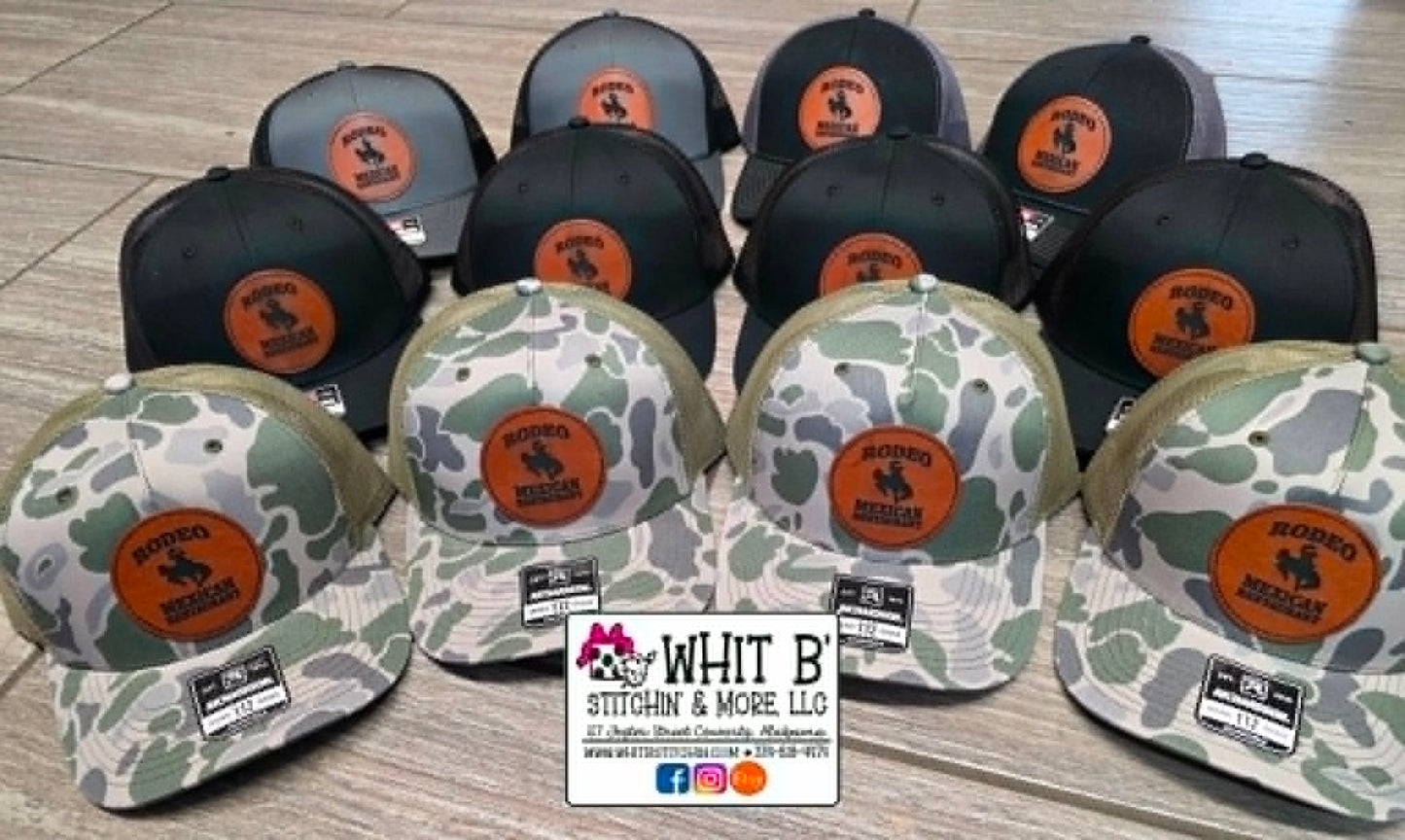 Black and camouflage trucker hats with custom round engraved leather logo patches