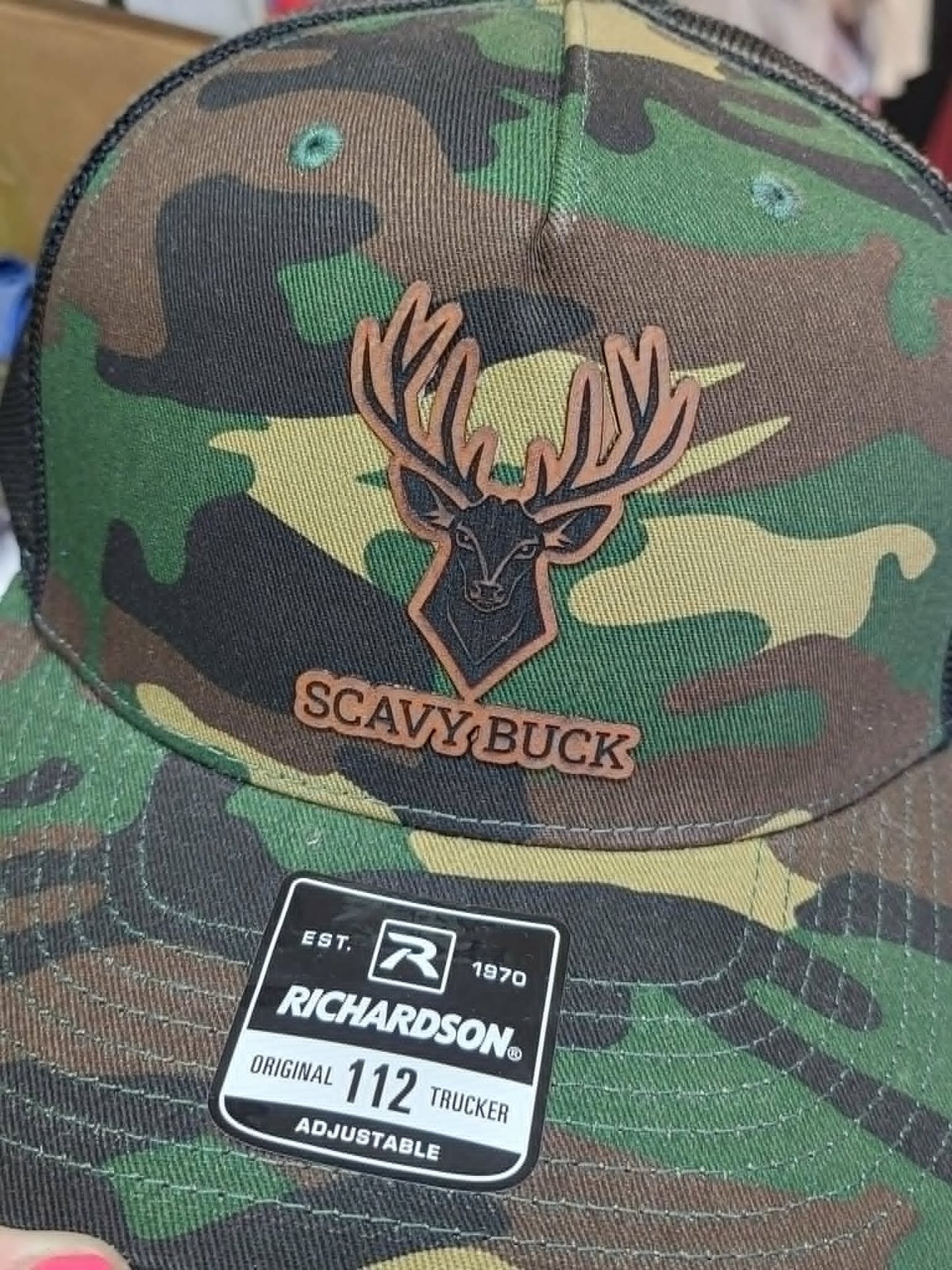 Green camouflage Richardson hat with layered wooden deer and Scavy Buck patch