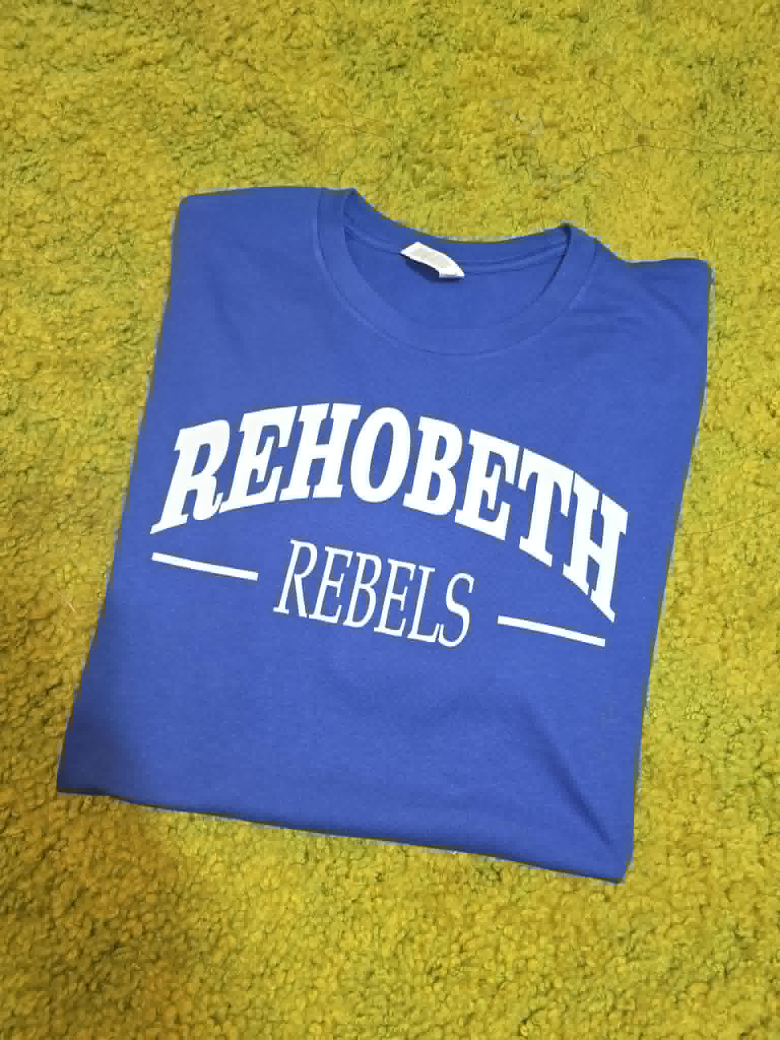 Blue Rehobeth Rebels shirt with classic white varsity lettering