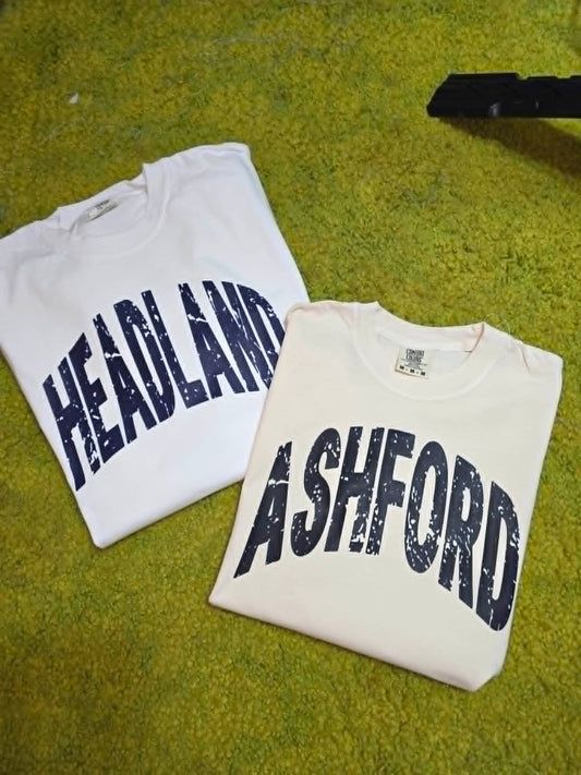 White Heflin and Ashford school spirit shirts with distressed navy lettering
