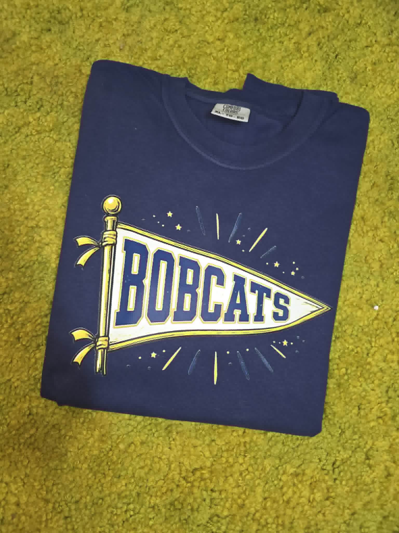 Navy Bobcats shirt with white, blue, and gold school pennant graphic