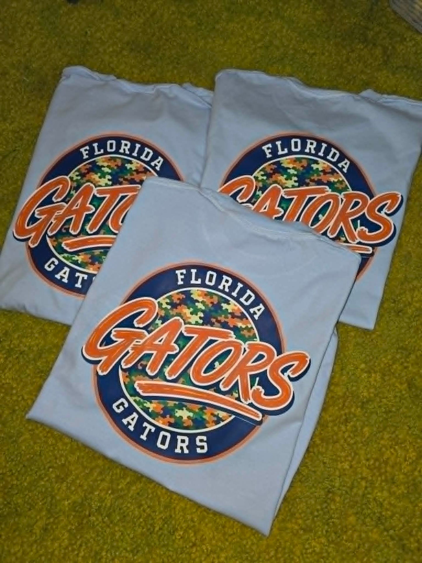 Light gray Florida Gators shirts with orange, navy, and camouflage circle graphics