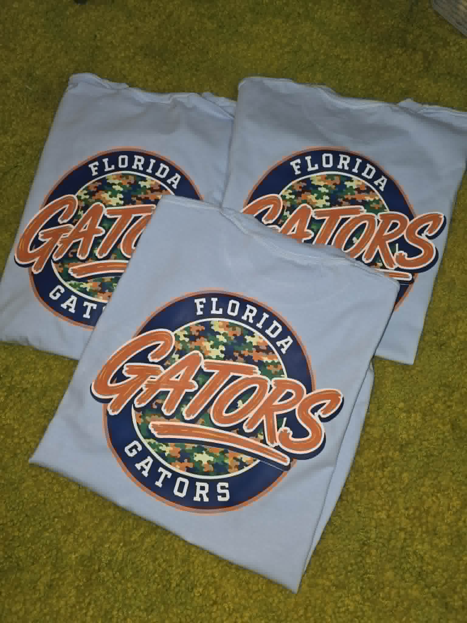 Light gray Florida Gators shirts with orange, navy, and camouflage circle graphics