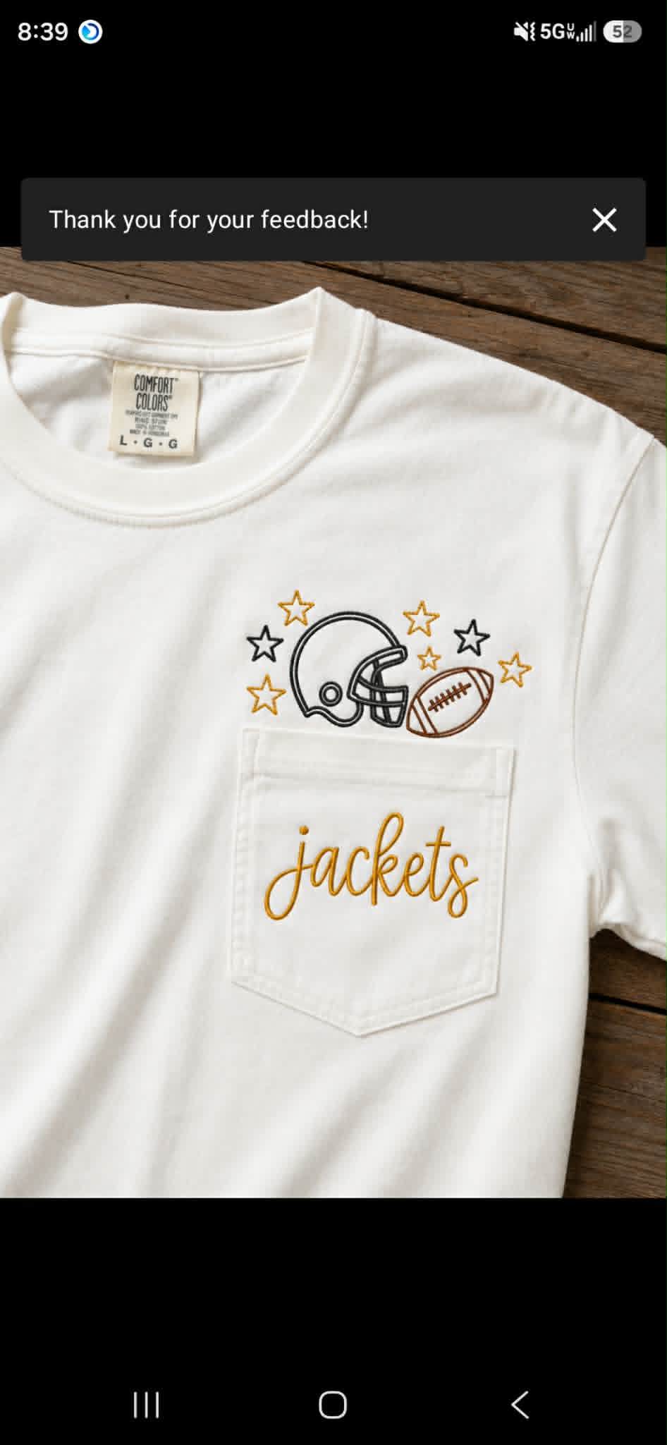 White pocket tee embroidered with football helmet, stars, ball, and Jackets script