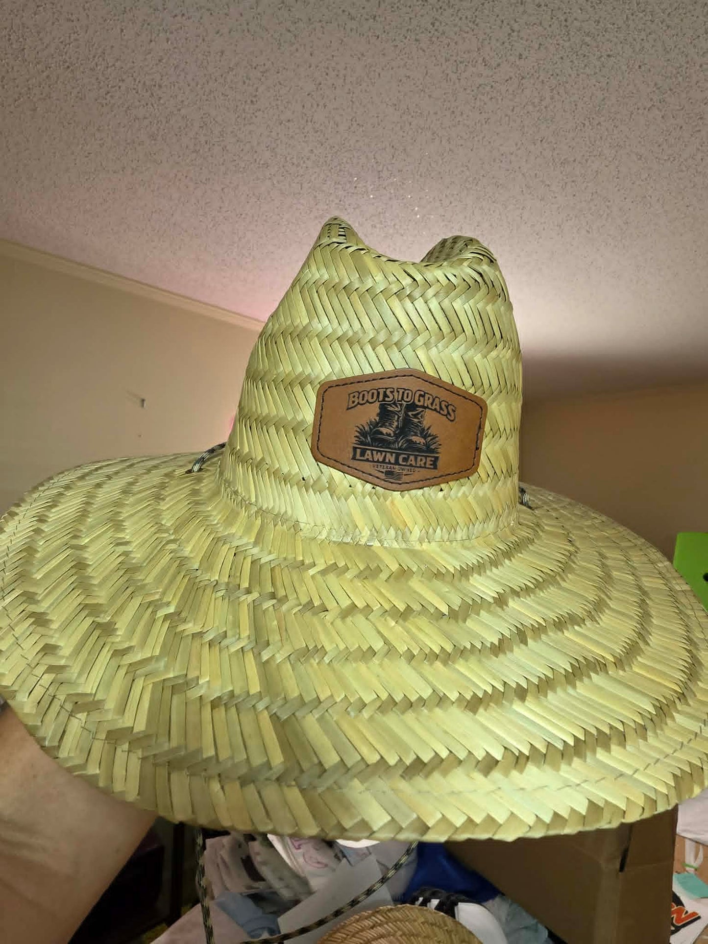 Straw sun hat with a Boots to Grass Lawn Care leather logo patch