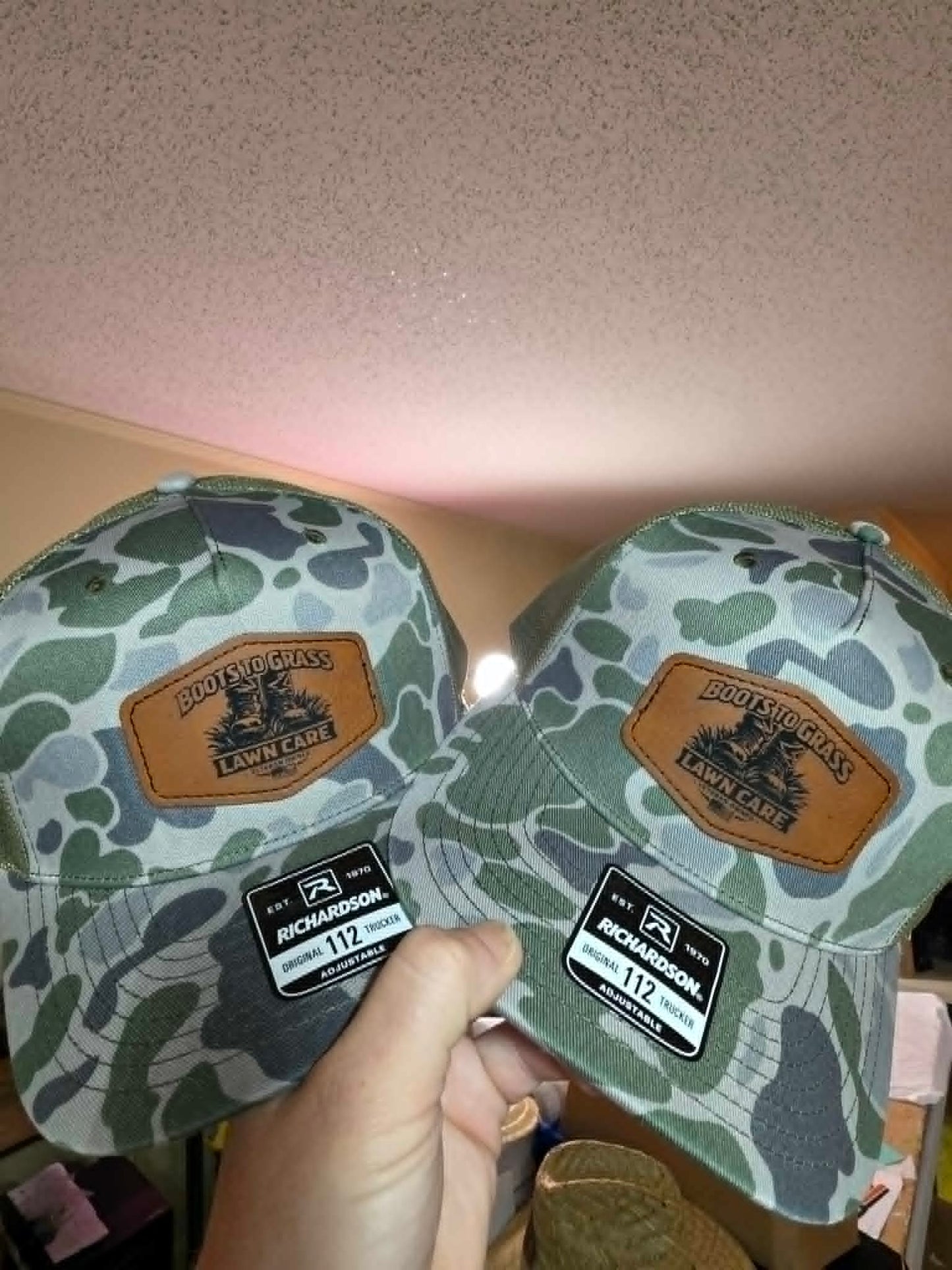 Camouflage trucker hats with Boots to Grass Lawn Care leather patches