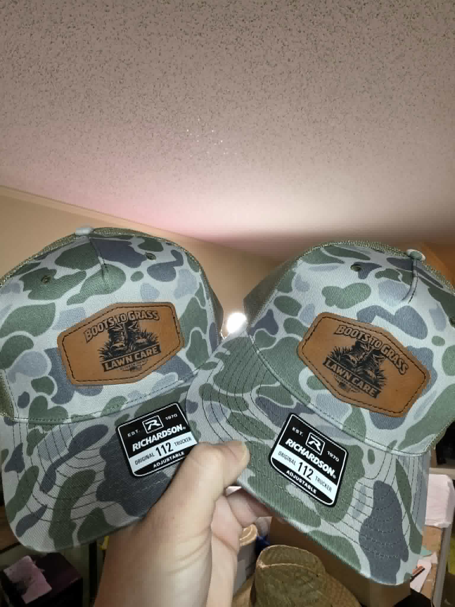 Camouflage trucker hats with Boots to Grass Lawn Care leather patches