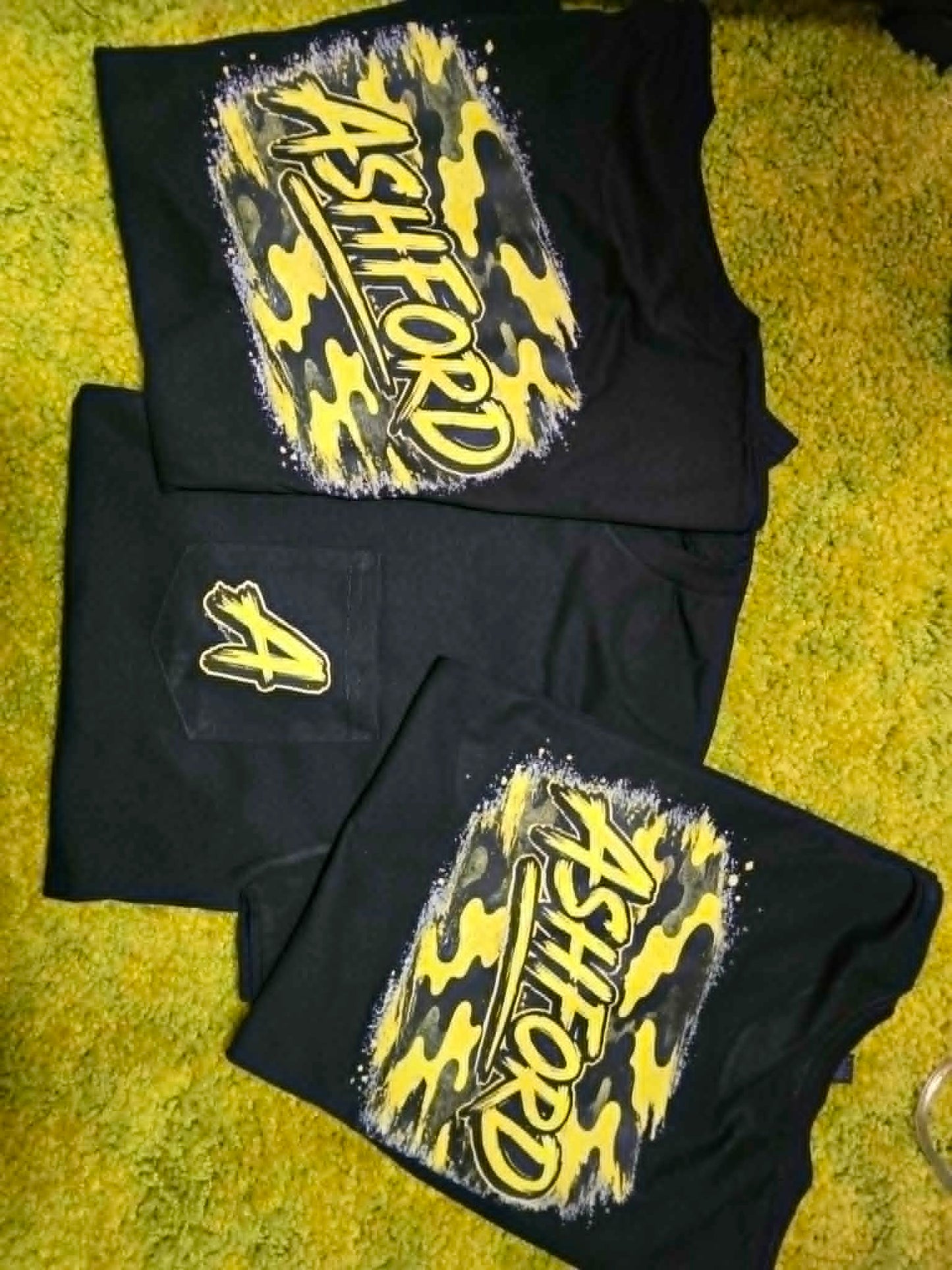 Black Ashford school spirit shirts and pants with yellow camouflage graphics