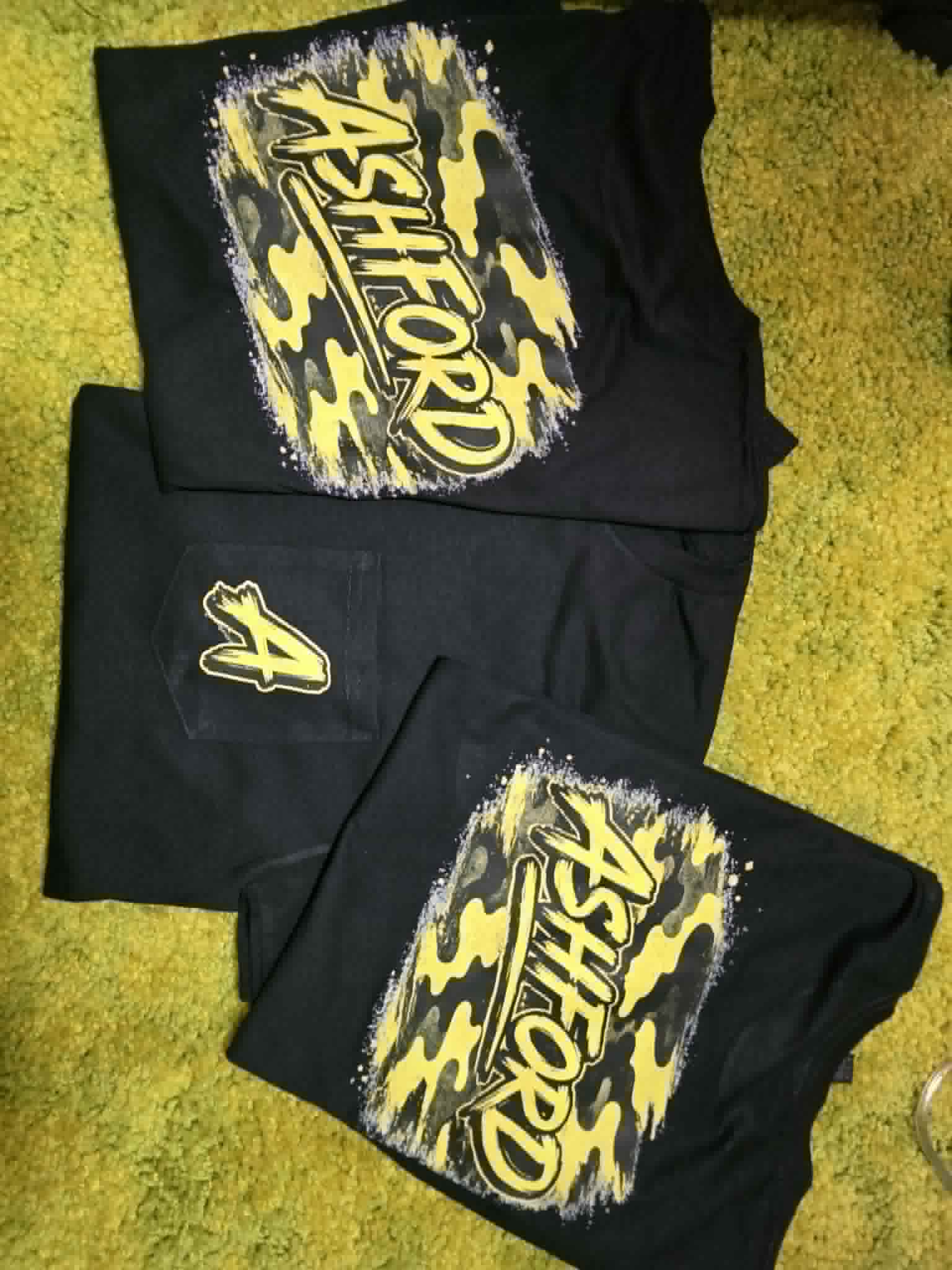 Black Ashford school spirit shirts and pants with yellow camouflage graphics