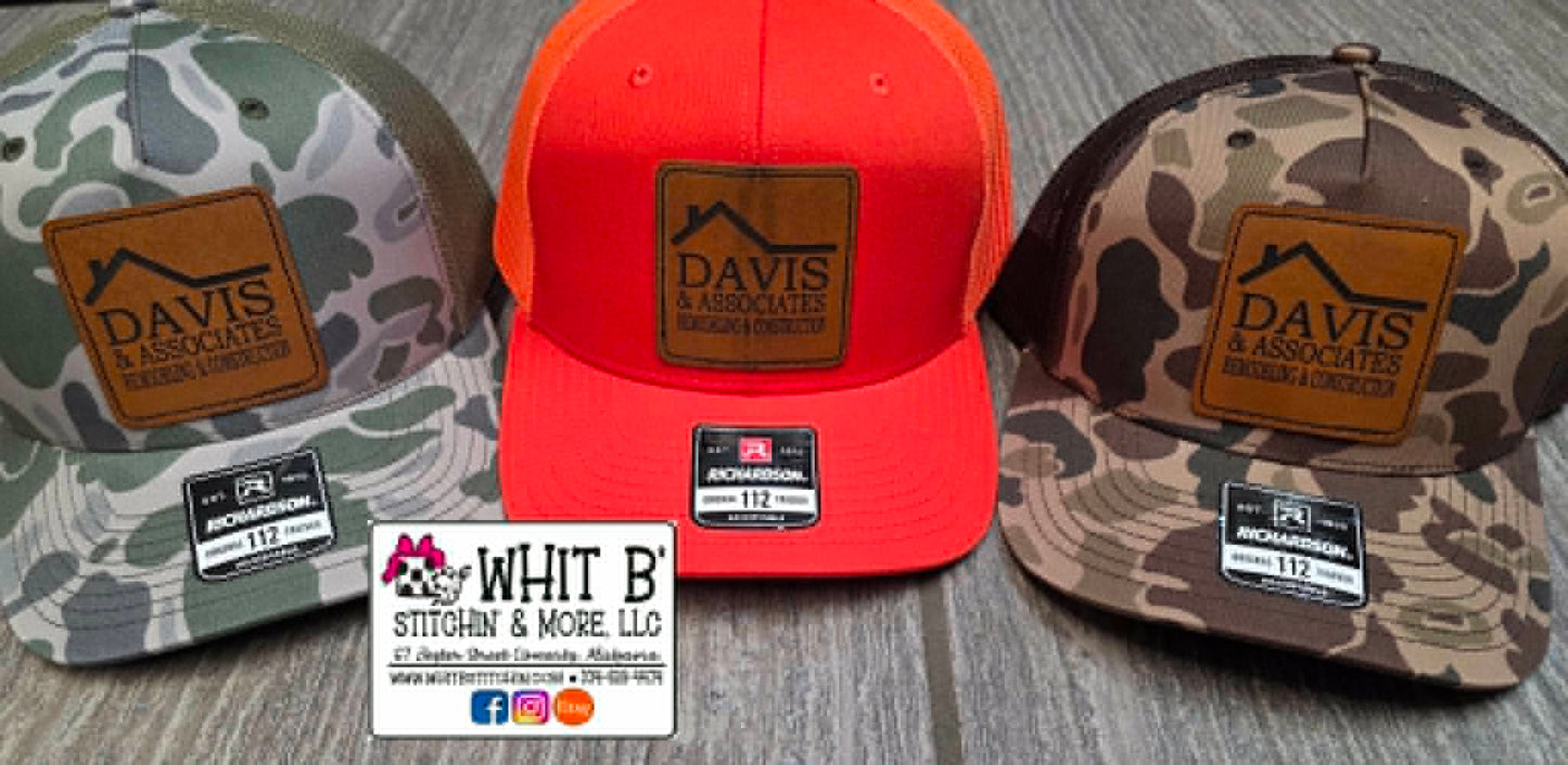 Camouflage and safety-orange hats with Davis & Associates leather logo patches