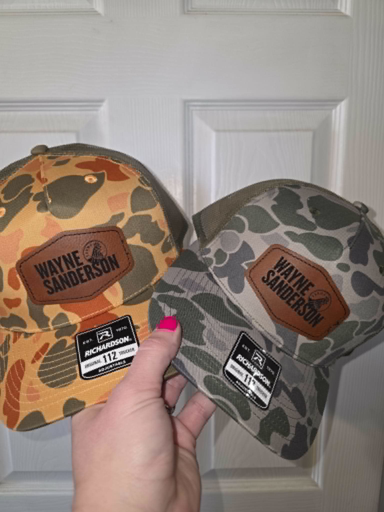 Orange and green camouflage hats with Wayne Sanderson leather patches