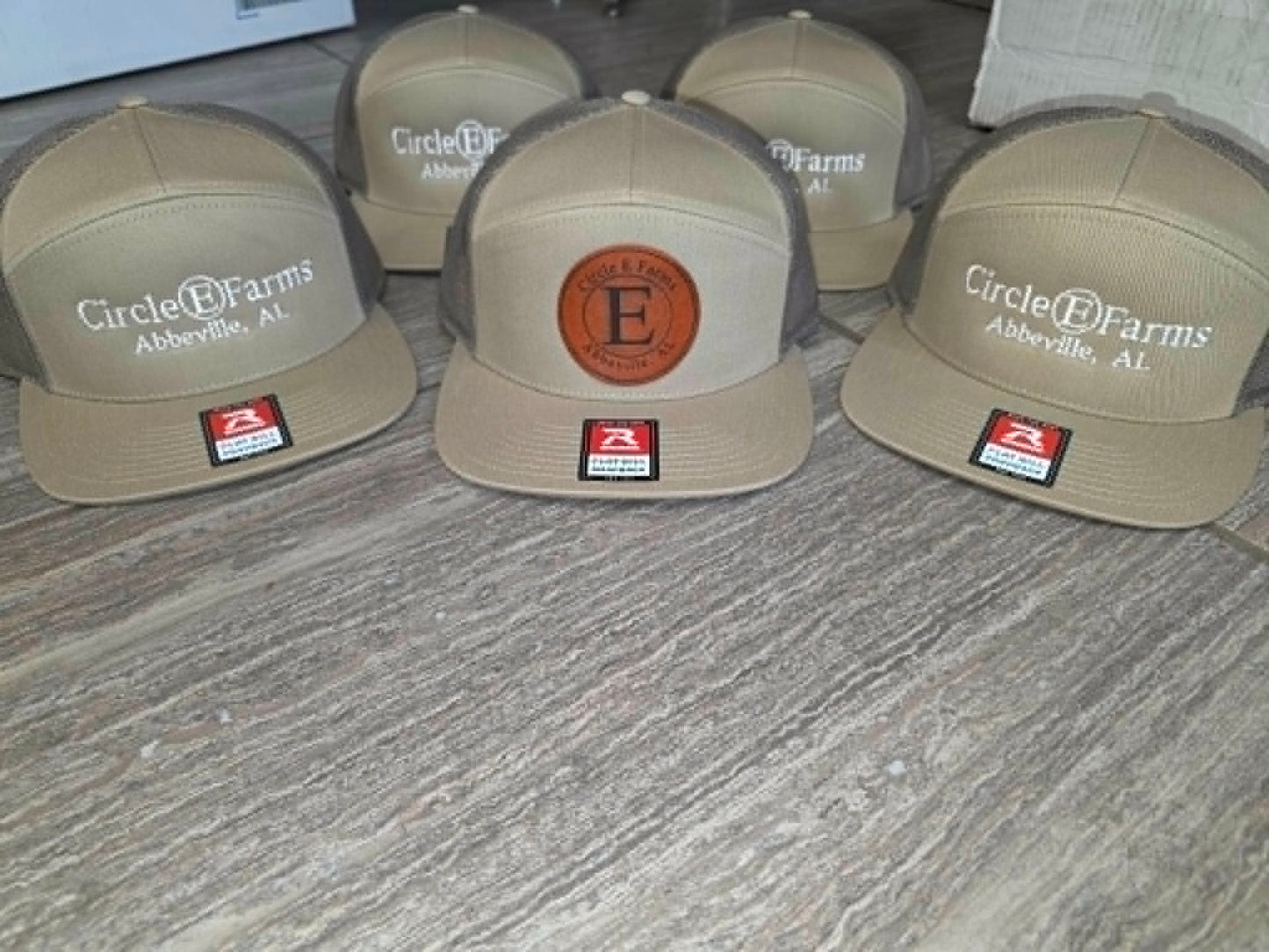 Tan Circle E Farms hats with embroidered logos and a round leather monogram patch