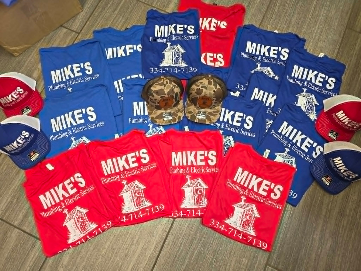 Red and blue Mike's Plumbing and Electric shirts with coordinated custom hats