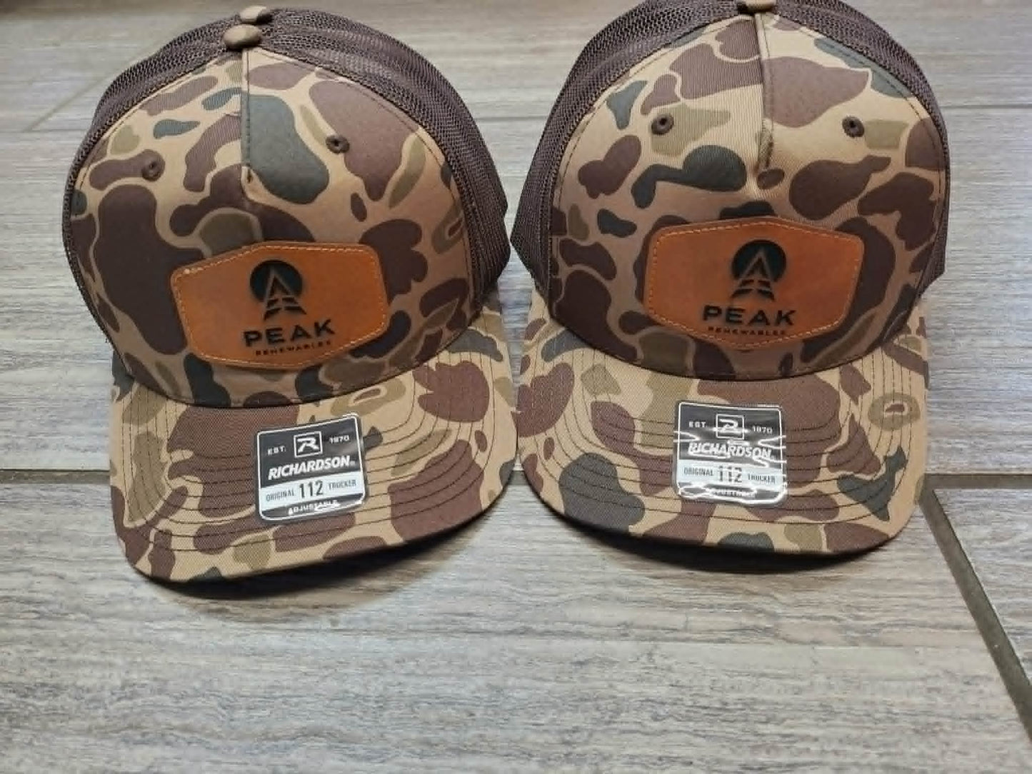 Brown camouflage Richardson trucker hats with Peak Renewables leather patches