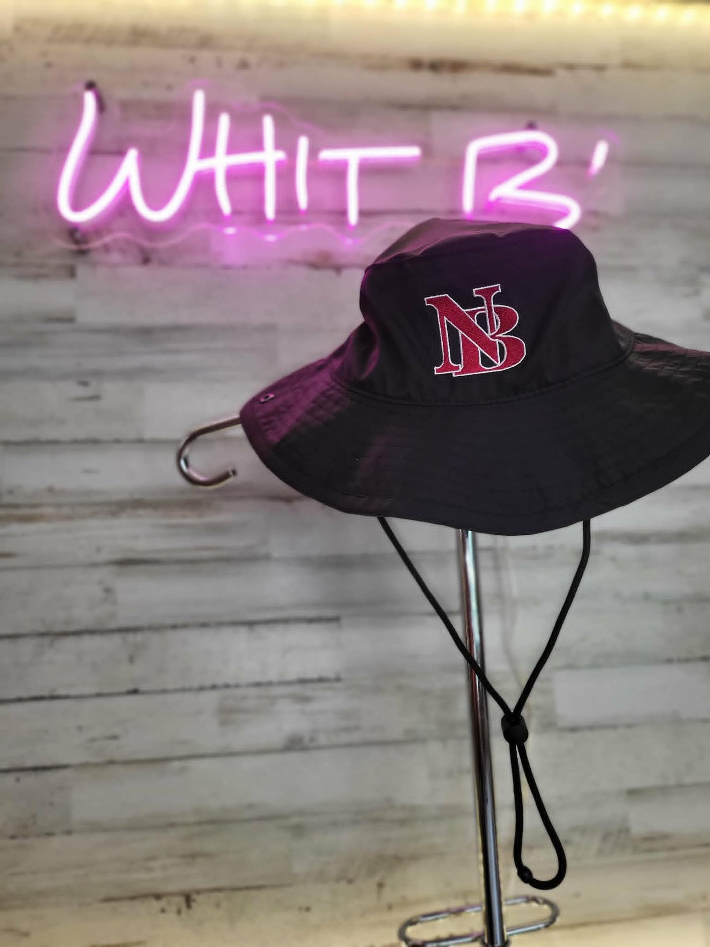 Black wide-brim sun hat embroidered with a red and white NB monogram