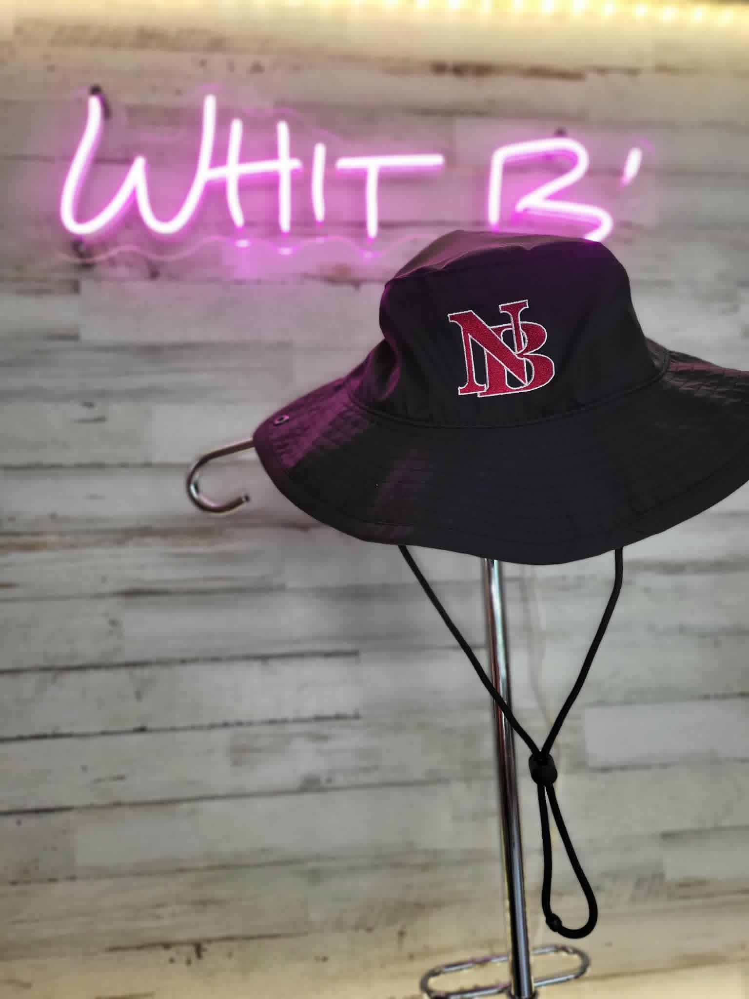 Black wide-brim sun hat embroidered with a red and white NB monogram