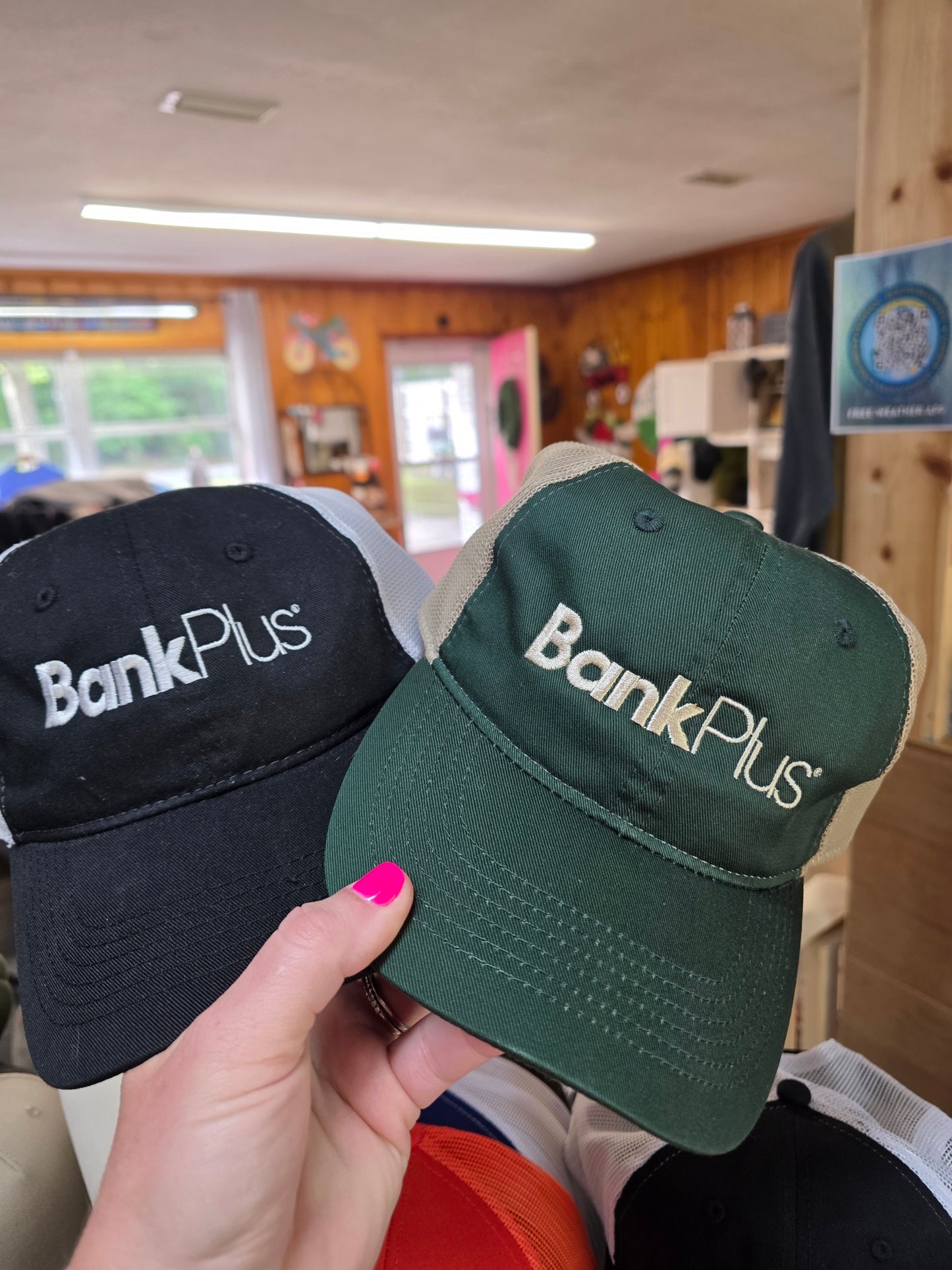 Black and green mesh trucker hats embroidered with the BankPlus logo